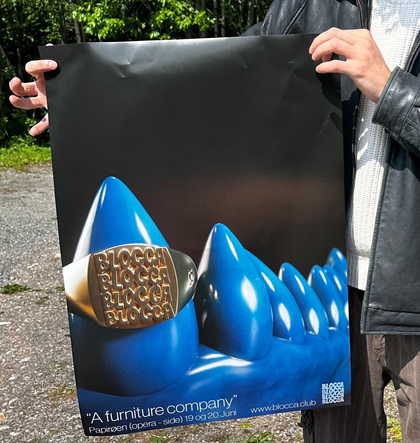 Hands holding an early Blocca poster with glossy blue forms