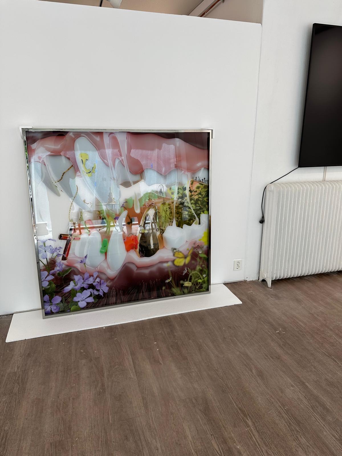 Framed Flesh and Flowers artwork leaning inside a studio room